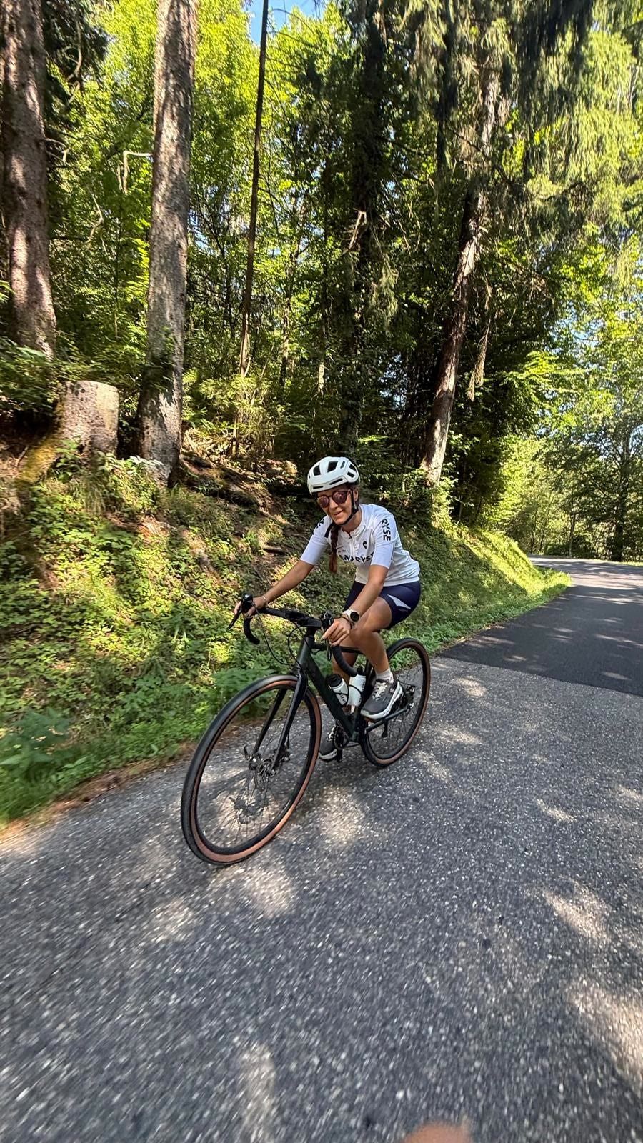 Marion à vélo sur une route boisée au-dessus d'Annecy